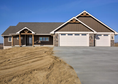 brown house driveway white garage doors grey roof