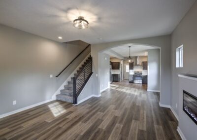 wide living room, wood flooring, chandelier,custom modern fireplace