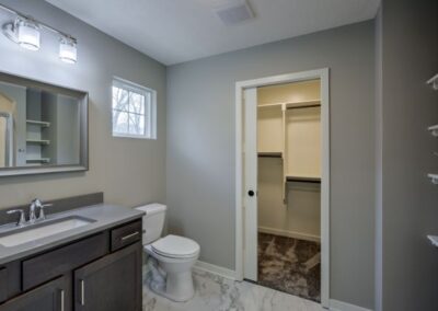 bathroom sink with cabinets, sliding door, window, bathroom lights