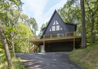 Modern A house with balcony, dark gray roof and wood sidings