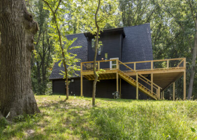 Modern A house with balcony, dark gray roof and wood sidings